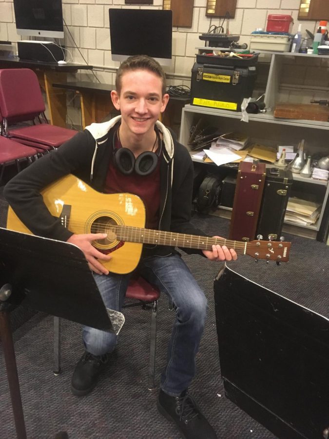 Senior Bradley Mcdowell sitting with his guitar