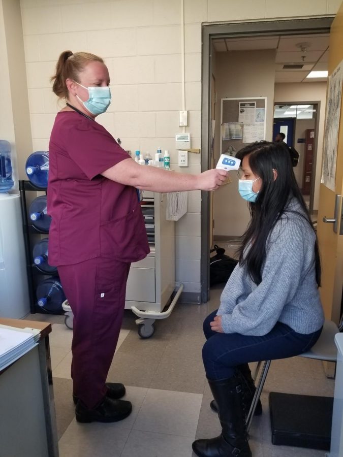 Nurse Bonnie Kecklers office is a very busy place this month. Here she is  taking a students temperature. 