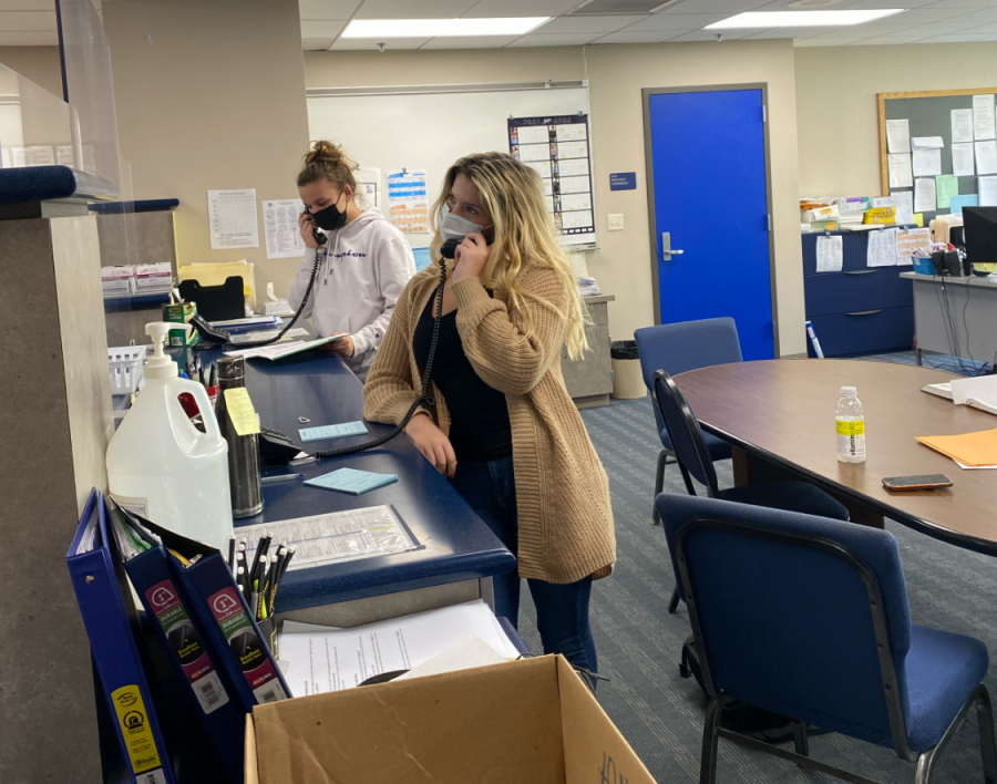 Students Samantha Stanley and Meghan Ogonowski both answer the phones while working in the office.
