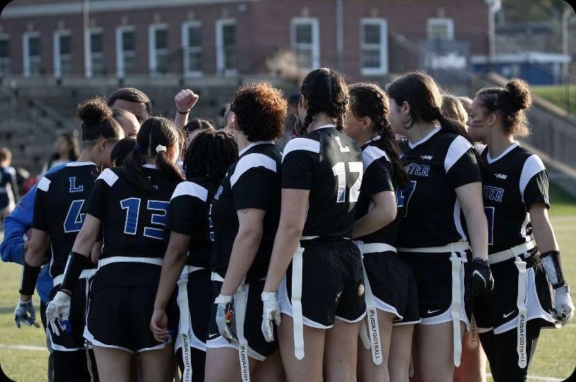 The team huddles before their inaugural game at Doyle Field