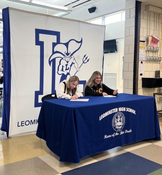 From left: Ava Troest and Nicole Kelly sign their college commitment letters. 