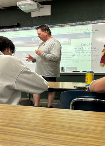 Sportswriter John McGuirk speaks with members of the Journalism class.