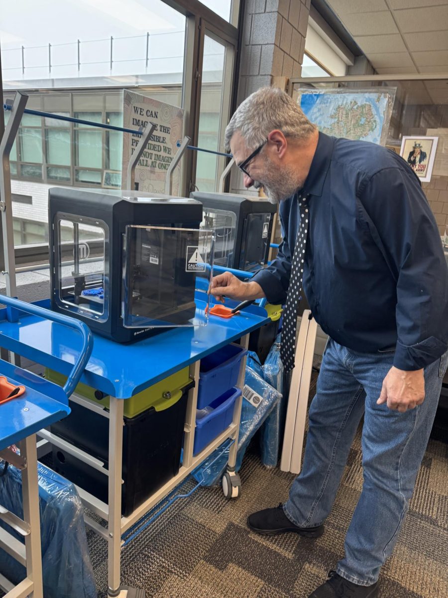 James Freel checks on a project in one of the Media Center's Makerspace's 3-D printers. 