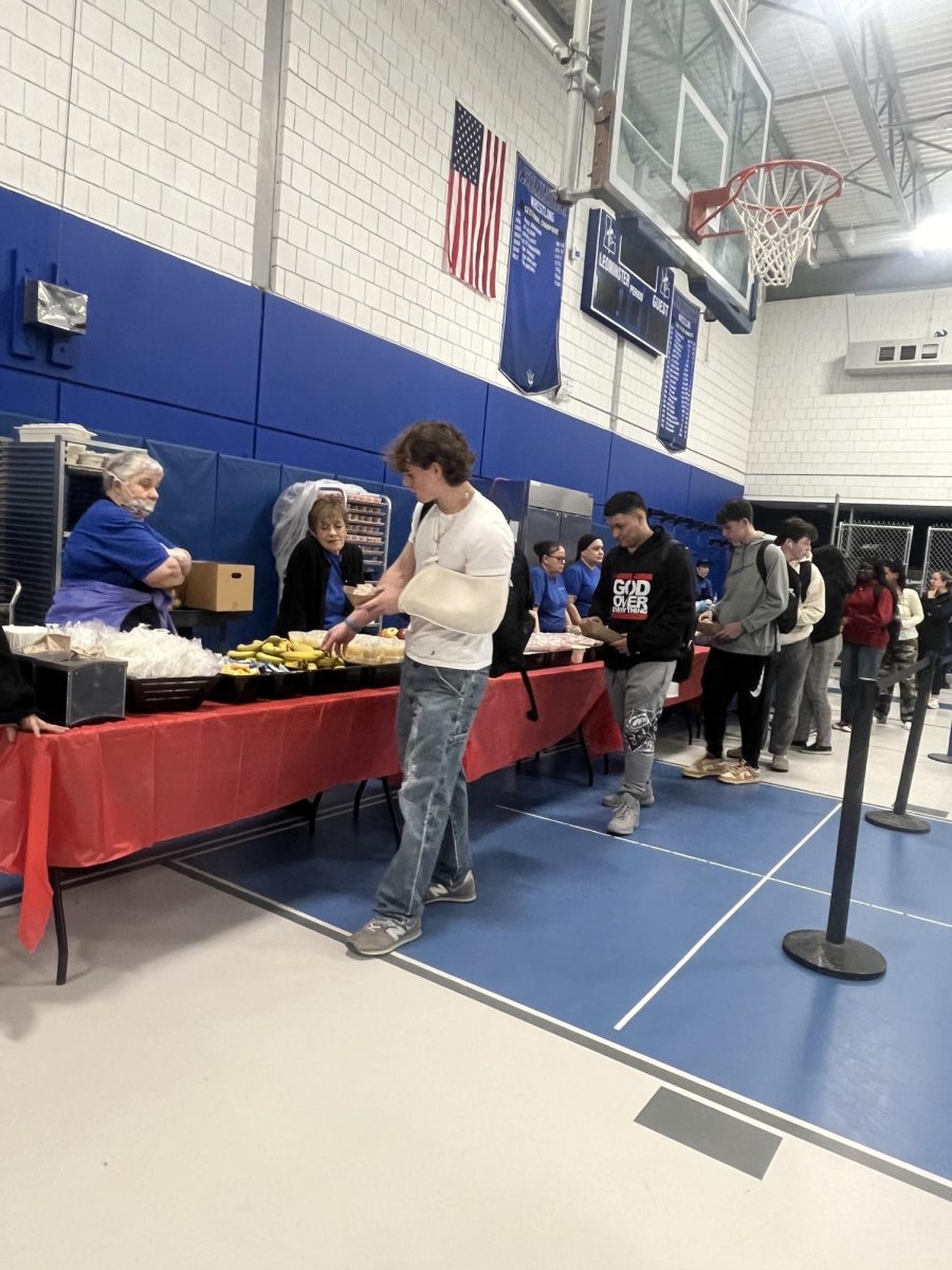 Students line up in the gym to get heir lunch before bringing it back to their classroom. 