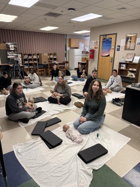Sophomore Health Occupation students practicing Infant CPR on baby dummies. 