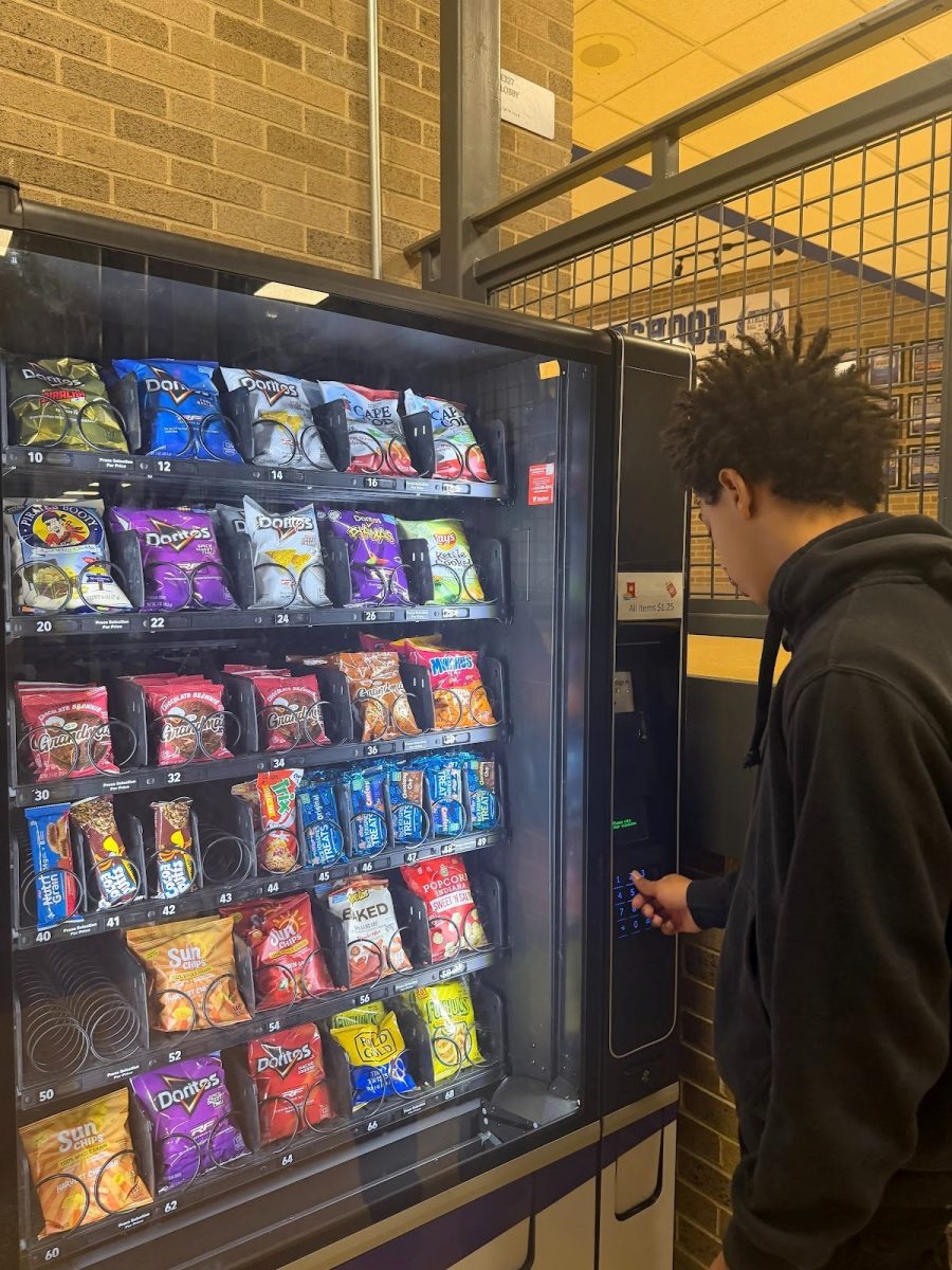 A student gets a snack from the vending machine between classes.
